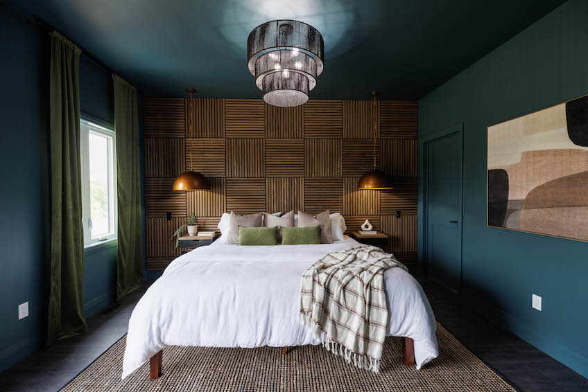 Dark bedroom with white bedspread and wood feature wall designs