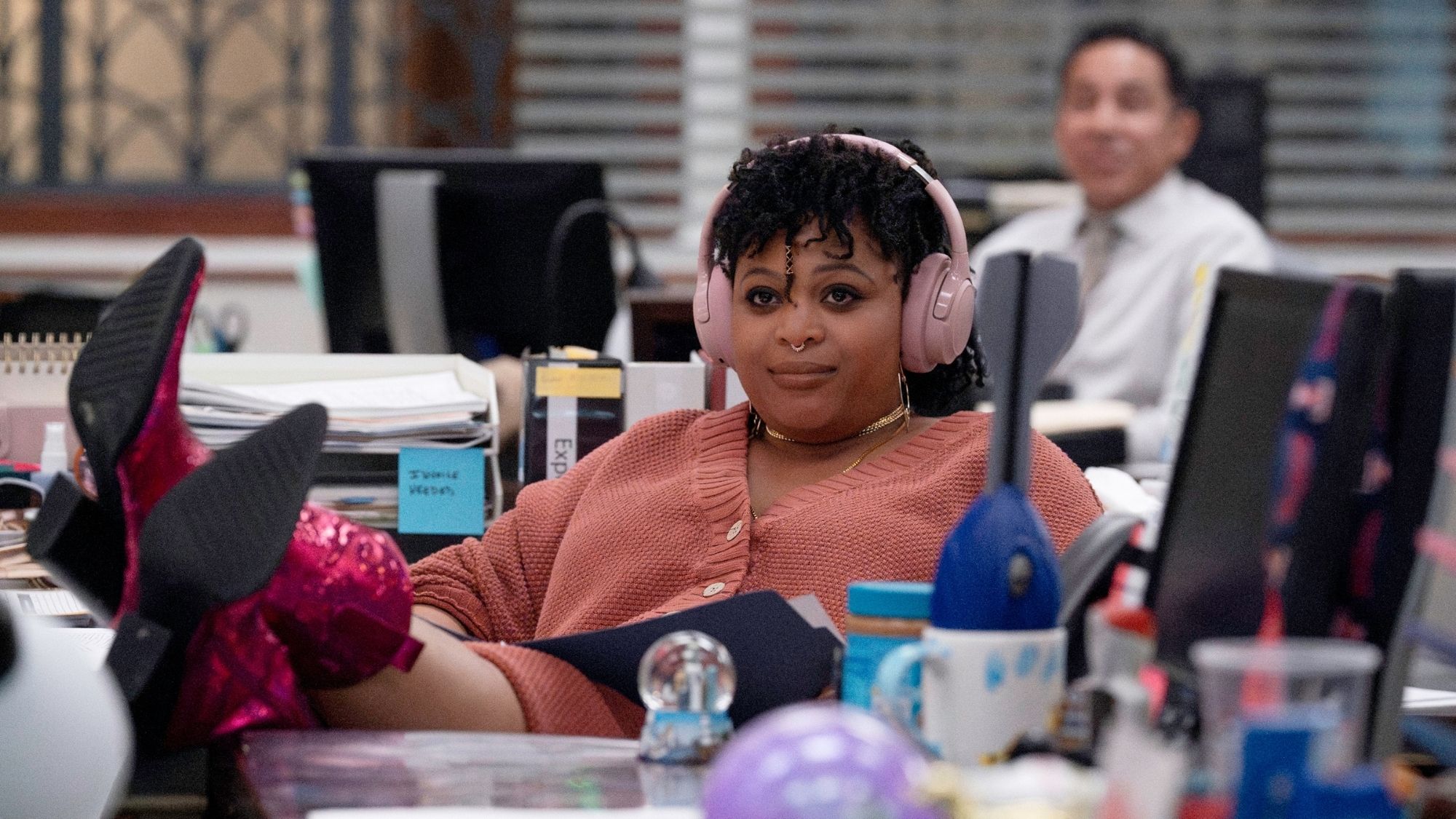 Listening to music, feet up on desk with sparkly pink boots