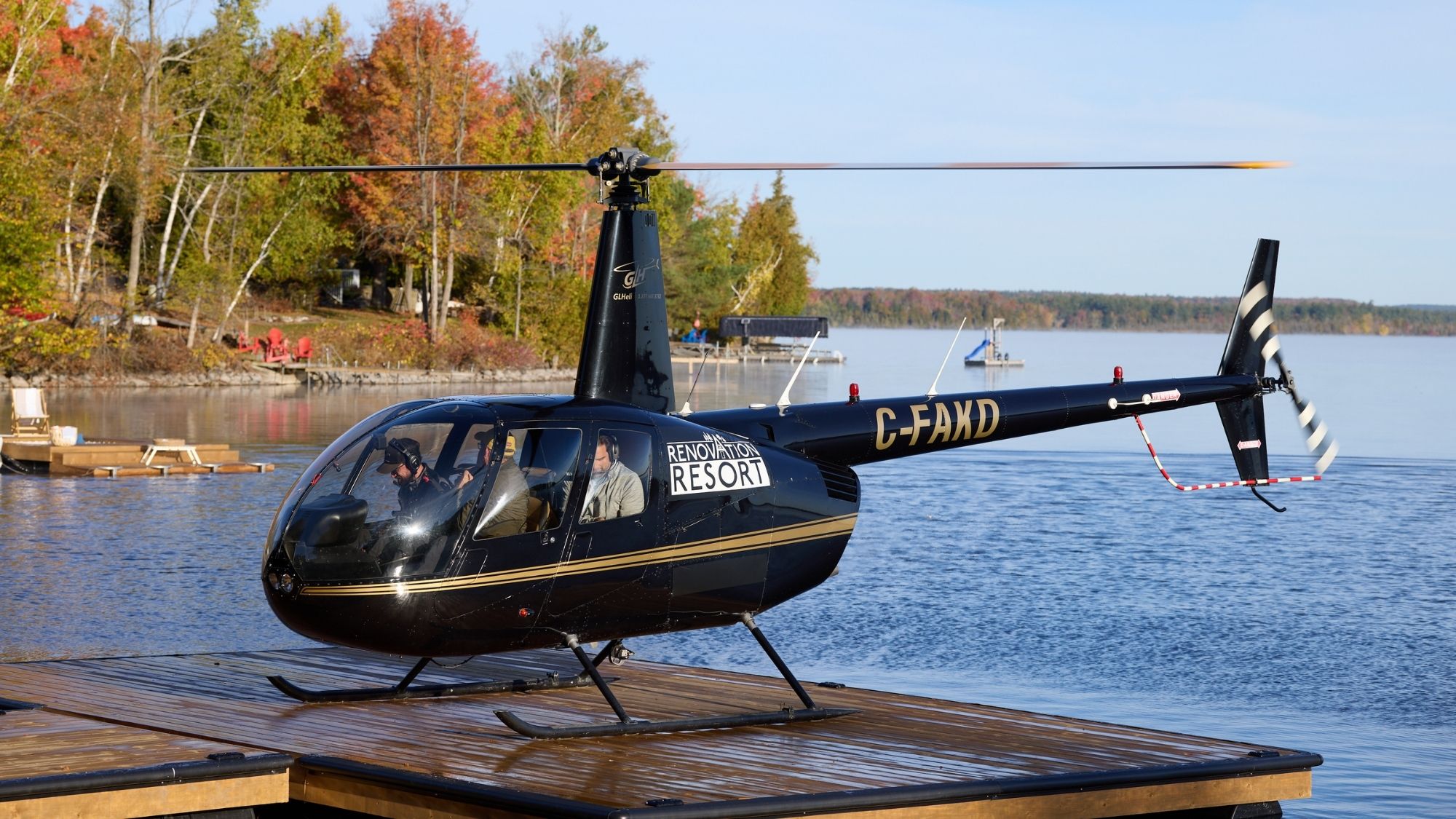 Helicopter landing next to lake with Renovation Resort logo on it